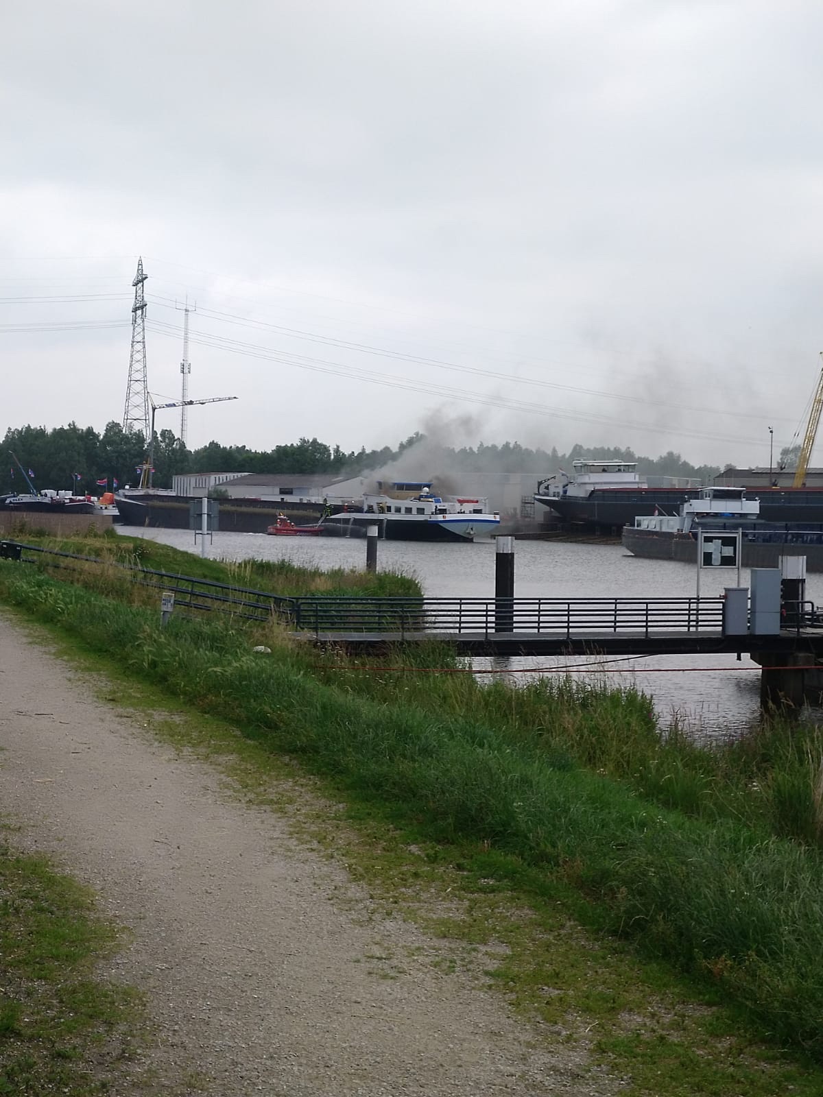 Rookwolken slaan uit de voormalige tanker die voor ombouw bij de werf van Ruijtenberg ligt (Foto RWS Gezagvoerder Arco)