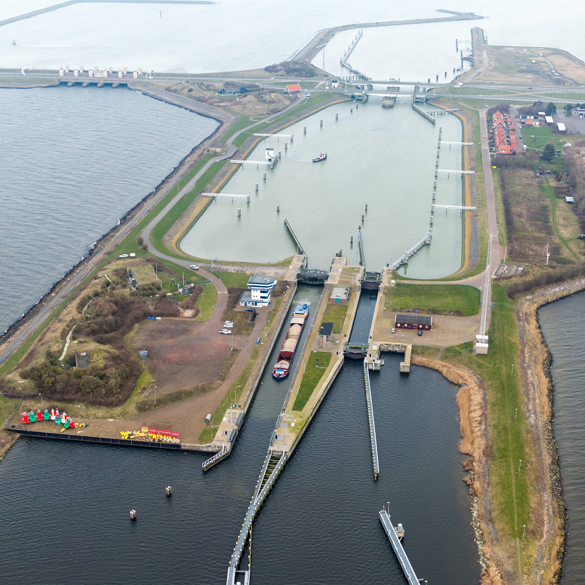 De doorgang van de sluis bij Kornwerderzand wordt breder, zodat er grotere schepen doorheen kunnen varen. (Archieffoto Witteveen en Bos)