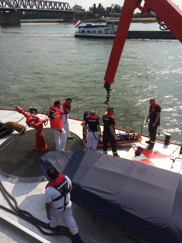 De gewonde schipper wordt aan boord van de blusboot gehesen. (Foto Feuerwehr Düsseldorf)