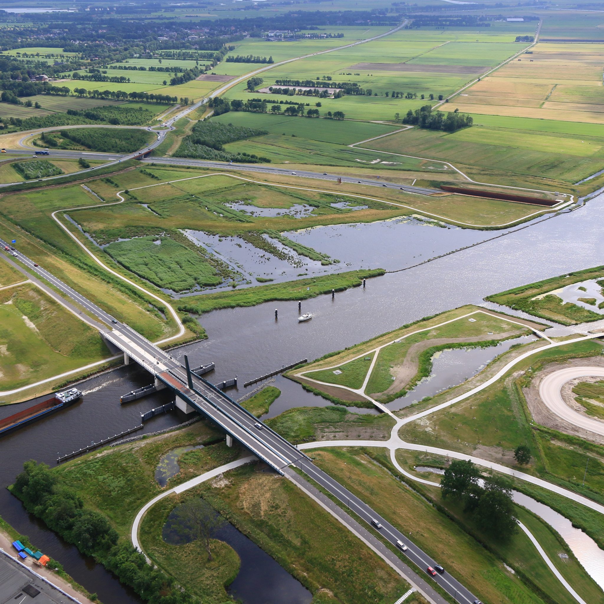 Rijkswaterstaat wil wachtende schepen op het Prinses Margrietkanaal bij de brug Bugumerdaam voorkomen. (Luchtfoto Rijkswaterstaat)