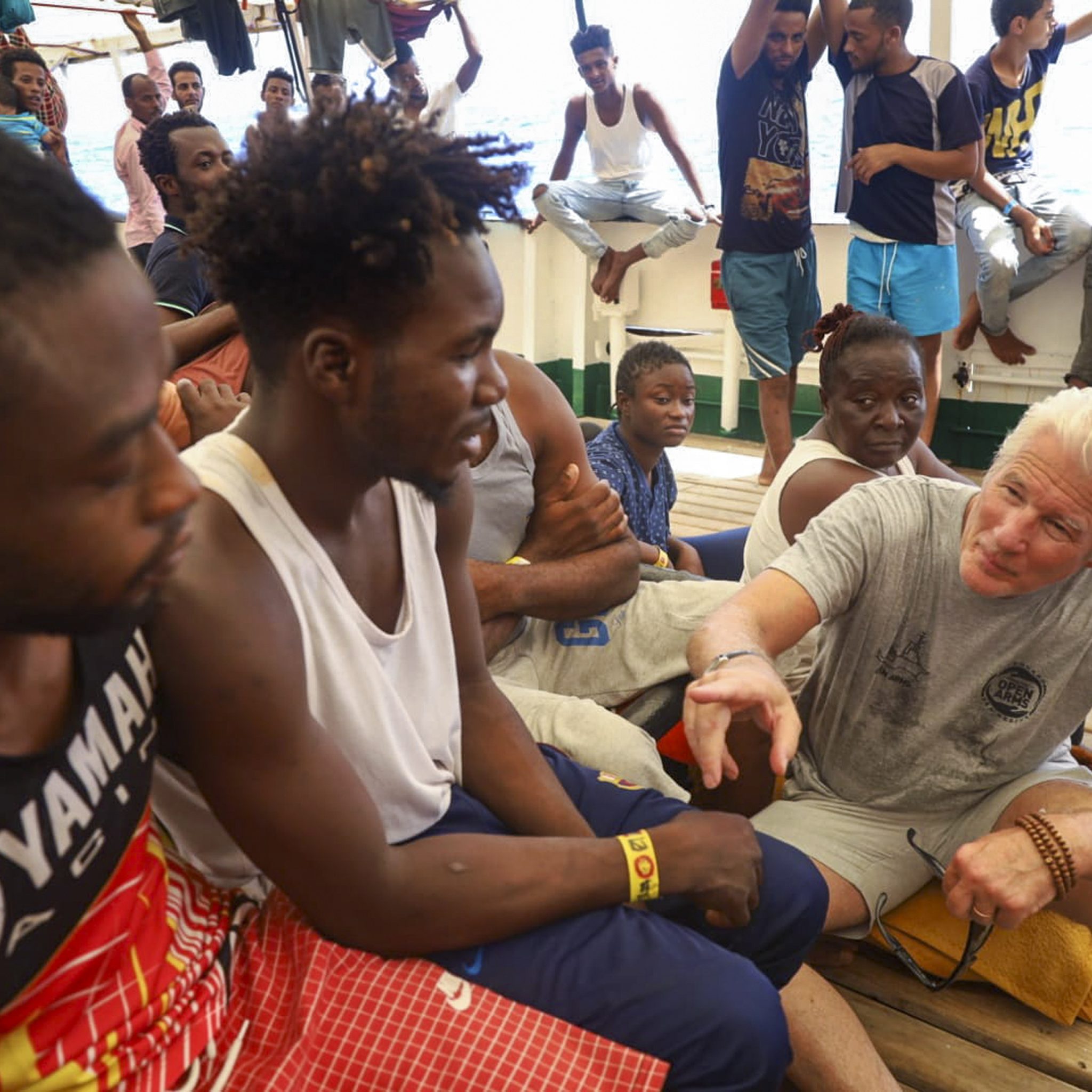 De Amerikaanse acteur Richard Gere vrijdag aan boord aan van de Open Arms in gesprek met bootmigranten. (Foto Valerio Nicolosi / Associated Press) 