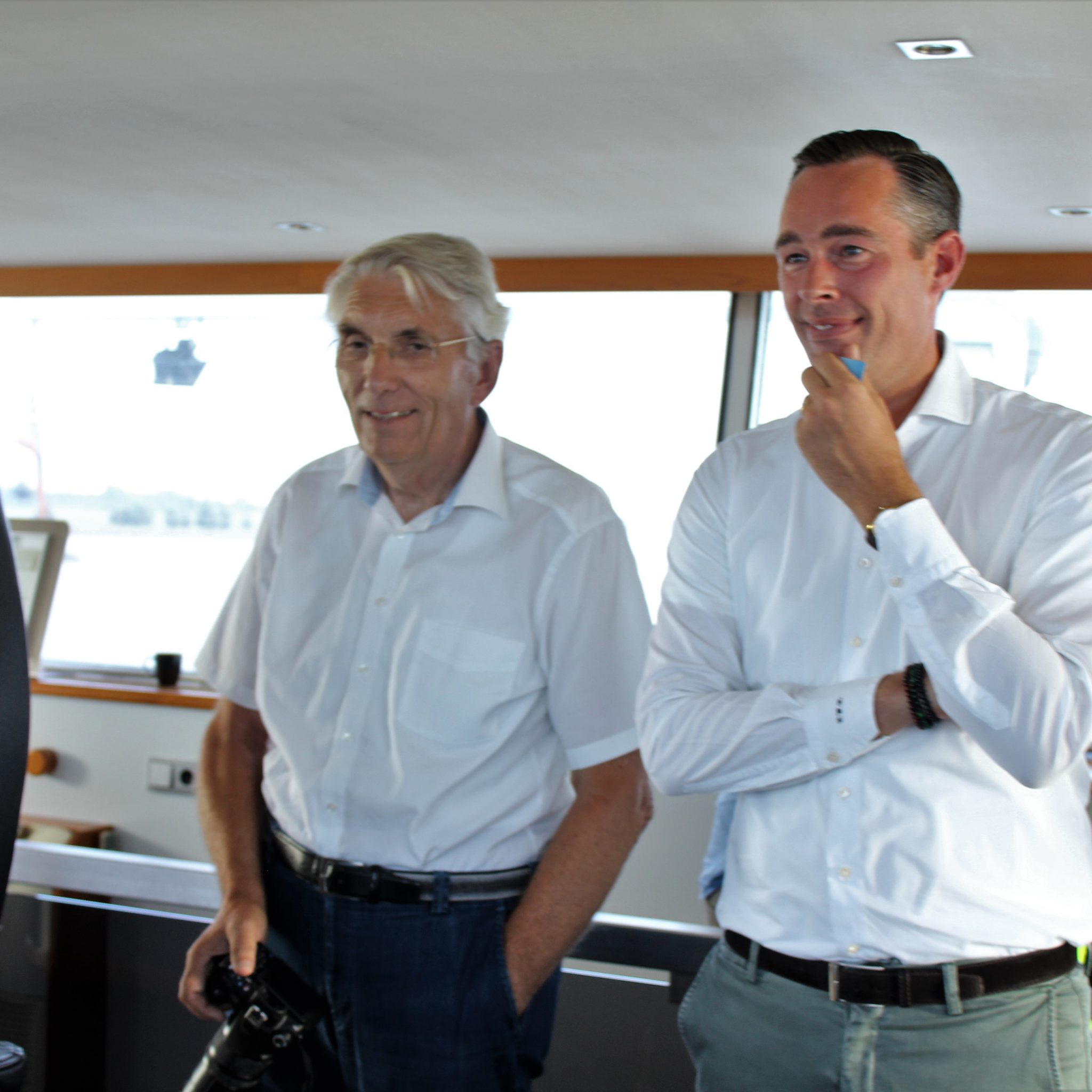 Martin van Dijk (midden) en Remco Pikaart kijken hoe de Black Box Pro de Factofour over de Nieuwe Merwede stuurt. Er zit niemand in de stuurstoel. (Foto Hans Heynen)