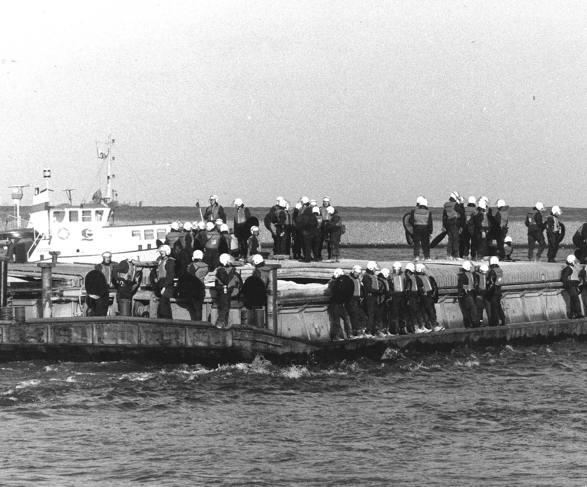 Onder begeleiding van de ME varen duwbakken van Granaria op 20 april 1988 naar hun bestemming, nadat ze eerder op de avond waren bezet door boze binnenvaartschippers, uit protest tegen een vervoervergunning, afgegeven door minister Smit-Kroes. (Archieffoto Paul Stolk / ANP)
