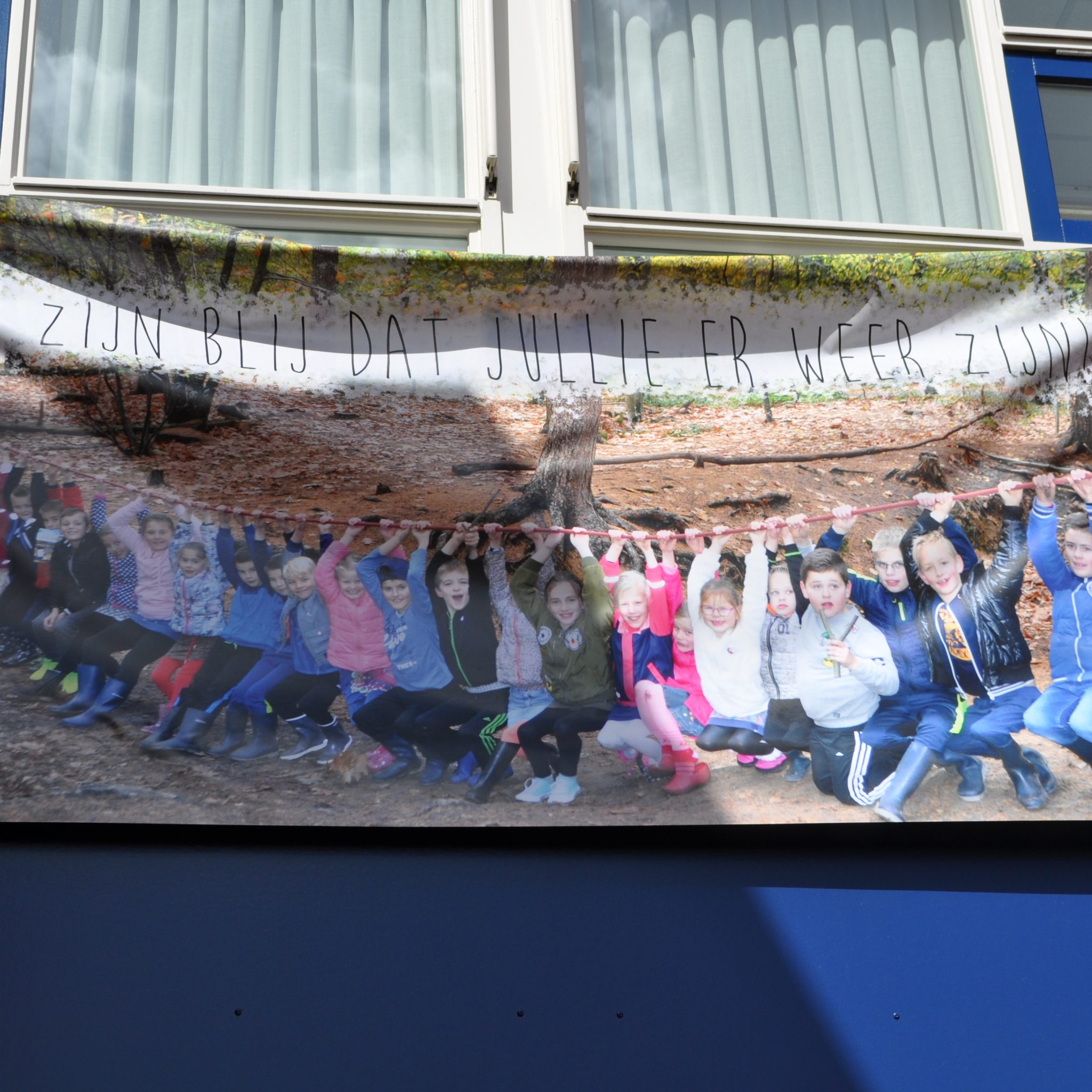 Met een enorm spandoek als welkom zien de kinderen van het internaat De Merwede zichzelf terug in Werkendam. (Foto Limena)