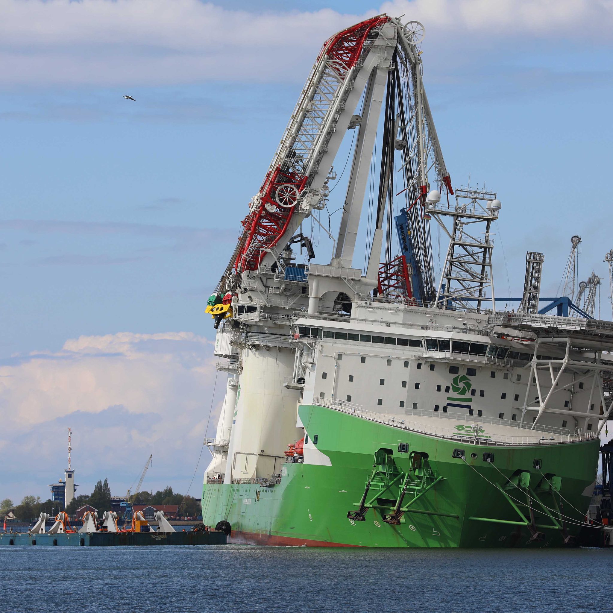 De nieuwe, afgebroken Liebherr scheepskraan op de Orion 1 in Rostock. Het offshore constructieschip van de Deme Group lag kort na het incident met slagzij tegen de kade. (Foto Stefan Tretropp)