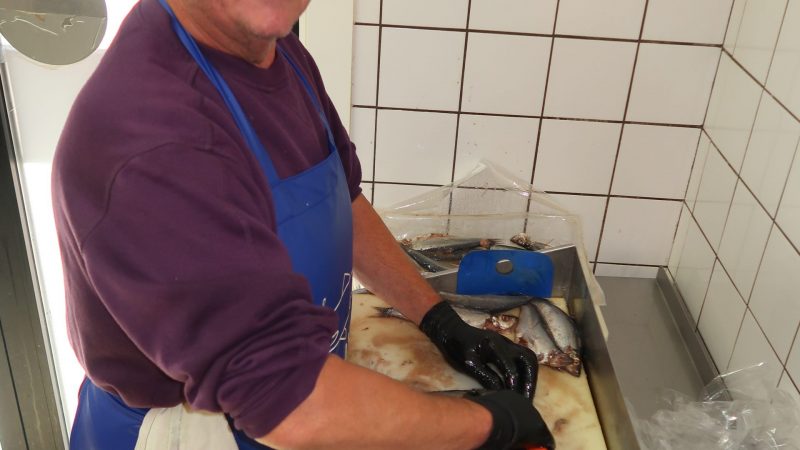 Na 48 jaar werken, helpt Jaap den Heijer nu in de viszaak van zijn broer. Daar snijdt hij maatjesharing. Zo’n 80 per uur als het moet. (Foto W.M. den Heijer)