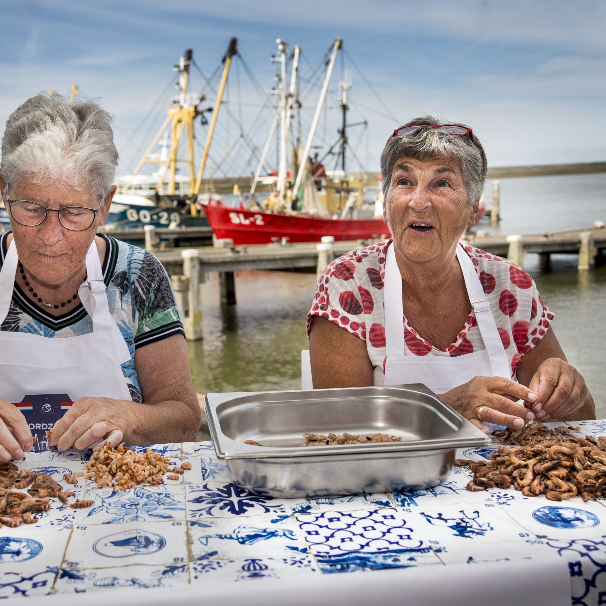 Met de hand worden garnalen gepeld in de haven van Stellendam. (Foto ANP / Arie Kievit)