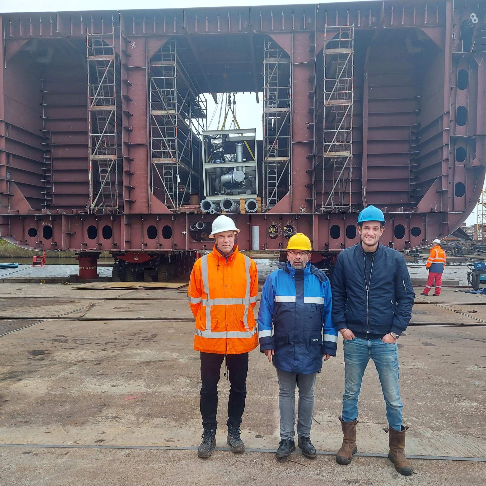De projectmanagers Casper Schilder, Lukas Venema en Niels Vroman (v.l.n.r.) voor het 270 ton zware scheepsdeel dat tussen het voor- en achterschip moet worden geplaatst. (Foto's Henk Zuur)