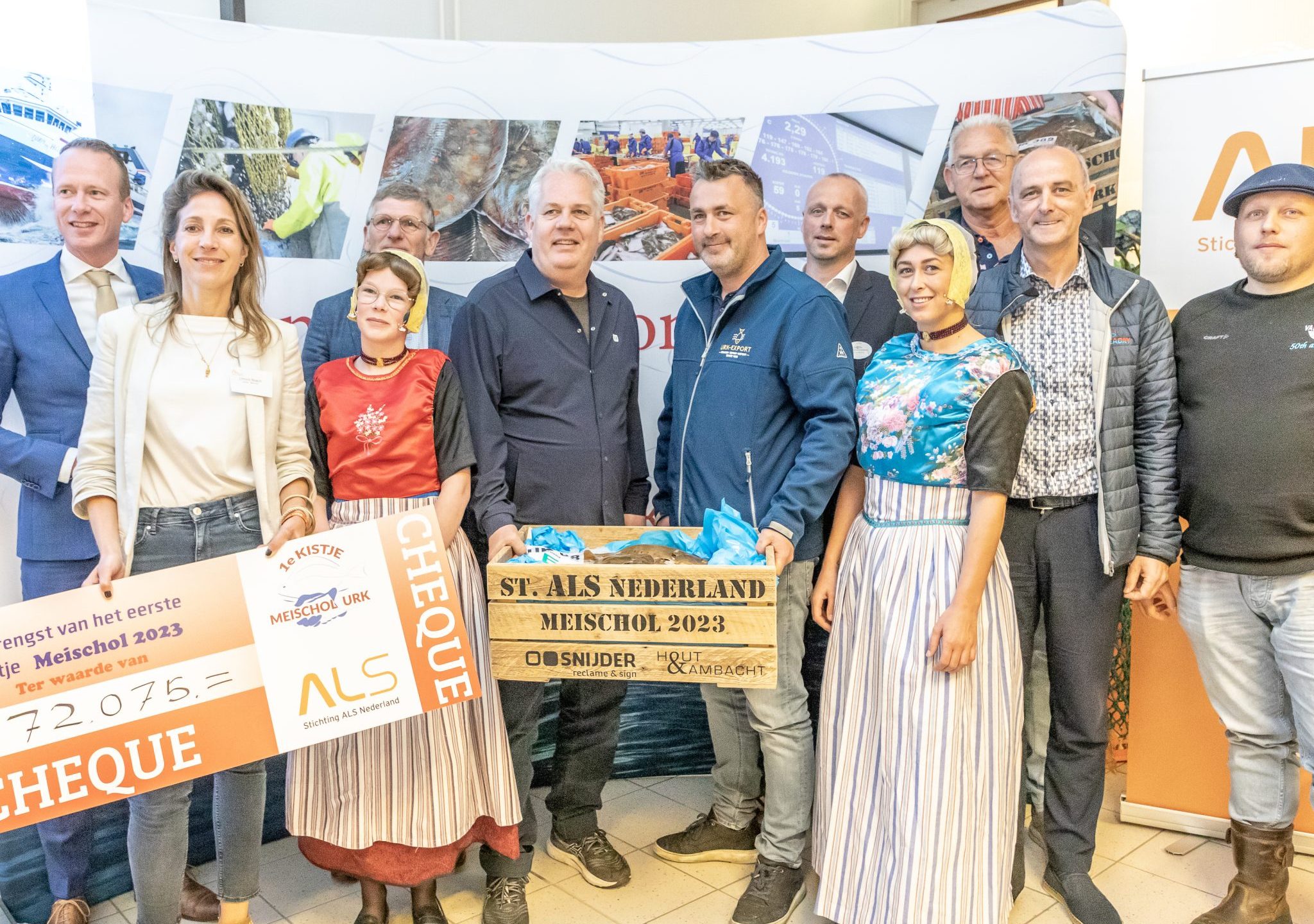 Limore Noach en Thomas Acda nemen namens Stichting ALS Nederland, te midden van bij de veiling betrokken bedrijven en instanties, de cheque in ontvangst.