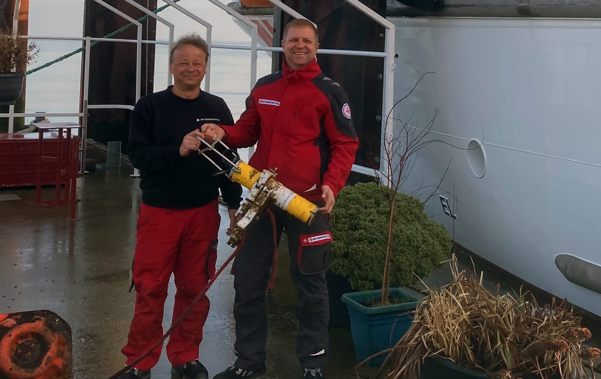 De redders Ralf Sarközy und Kai Schöps van de DGzRS reddingskruiser Anneliese Kramer met de boei.
